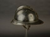 a silver helmet on a stand on a black background