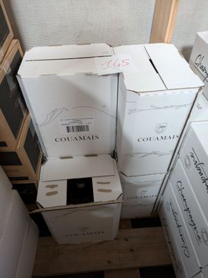 boxes of wine are stacked on top of each other in the corner of a room