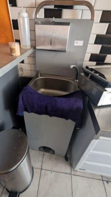 a sink and a trash can in a small kitchen