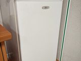 a white refrigerator in the corner of a small kitchen