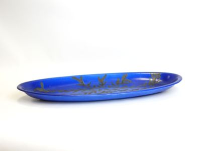 blue plate with gold design on it sitting on a white surface