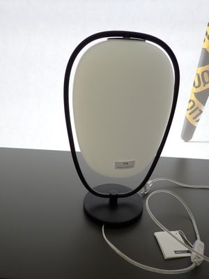 une lampe posée sur une table à côté d'un téléphone portable