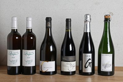 plusieurs bouteilles de vin sont alignées sur une table en bois