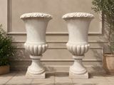 deux vases blancs posés l'un à côté de l'autre par terre
