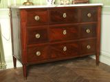 a dresser with a marble top in the corner of a room