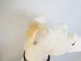 une figurine de chien blanc avec une cravate noire autour du cou