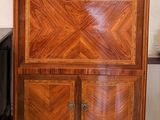 une armoire en bois avec un plateau en marbre, posée sur un tapis vert