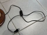 un cordon noir branché à un chargeur posé au sol