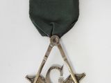 masonic square and compass on a green ribbon on a white background