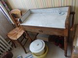 une petite table sur laquelle se trouve un bol, dans un coin de la pièce