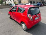une petite voiture rouge garée sur un parking