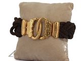 bracelet with a gold buckle on a black cord