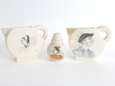 trois pièces de poterie posées sur une table