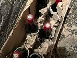 bottles of wine in a cardboard box on the ground next to a wall