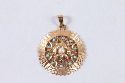 une image représentant un pendentif en or orné de pierres de turquoise sur fond blanc