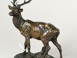 a bronze statue of a deer with antlers standing on a rock