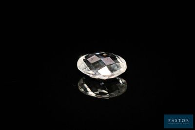 un diamant blanc sur une surface noire, avec un reflet