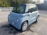 a small blue car parked in a parking lot
