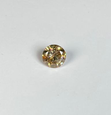 gros plan d'un diamant jaune sur une surface blanche