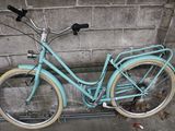 a blue bicycle parked against a brick wall