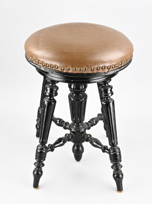 an image of a black stool with a brown leather seat