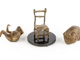 a statue of a chair, a chair, and a fish on a plate