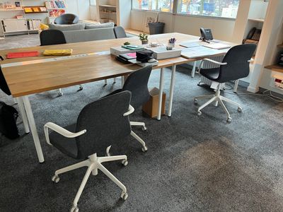 a table with chairs and a laptop on it in a room