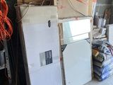 a room with a refrigerator, refrigerator freezer, and other items in it
