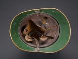 an old green helmet with a hole in the middle of it