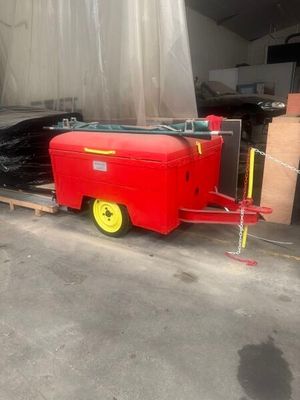 a red trailer with a yellow wheel parked in a garage
