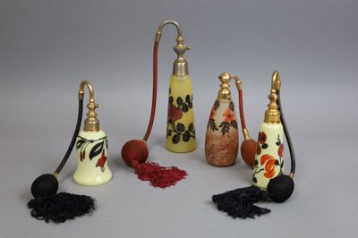 several different types of perfume bottles with tassels on a white surface