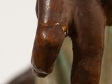 a bronze statue of a hand holding a piece of wood