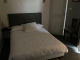 un lit blanc dans une petite chambre avec une fenêtre