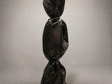 a black sculpture of a woman ' s head on top of a black base