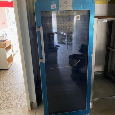 une porte bleue avec un seau à l'intérieur, dans une pièce