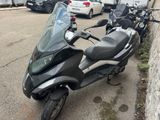 a scooter that is parked on the side of the street