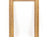 a gold framed mirror against a white wall