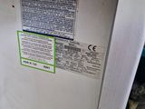 a white refrigerator with a green sticker on it