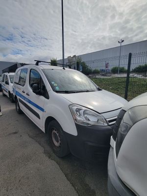 une camionnette blanche garée dans un parking à côté d'autres voitures