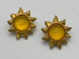 pair of yellow glass sunbursts on a white surface