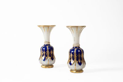 pair of blue and white vases sitting on top of a white surface