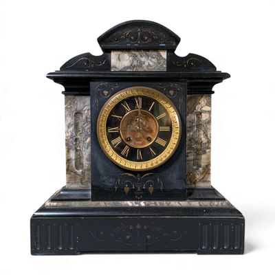 a black and gold clock sitting on top of a table