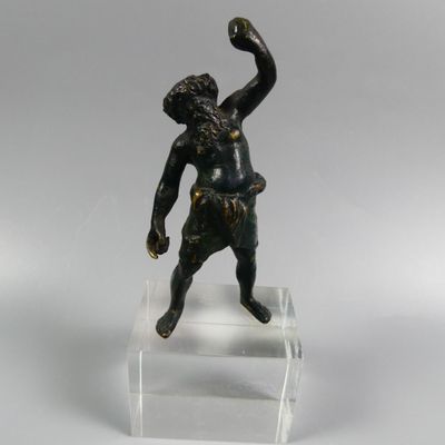 figurine en bronze représentant un garçon lançant une balle, posée sur un socle en acrylique transparent