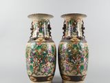 pair of chinese vases with floral designs on them on a gray background