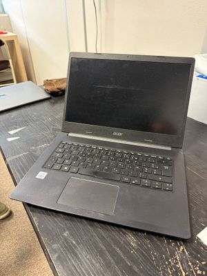 un ordinateur portable posé sur un bureau en bois