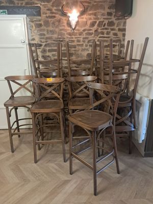 de nombreuses chaises en bois dans une pièce aux murs en briques