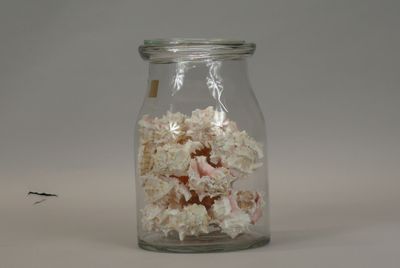 a glass jar filled with a mixture of white and pink flowers