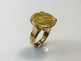 an image of a gold ring with a coin on it