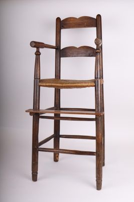 une chaise haute en bois avec une assise tressée sur fond blanc