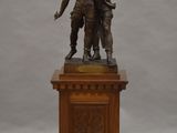 statue en bronze représentant un garçon et une fille sur un socle